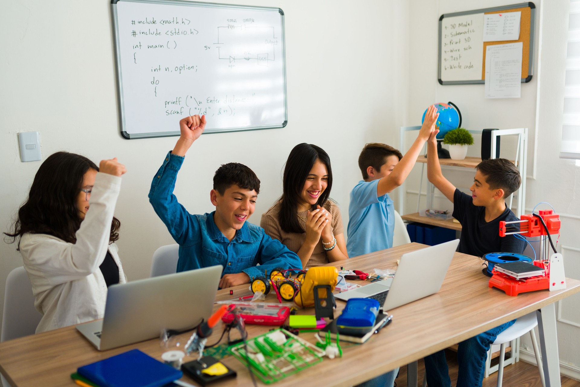 Cheerful young boy and girls enjoying their robotics course