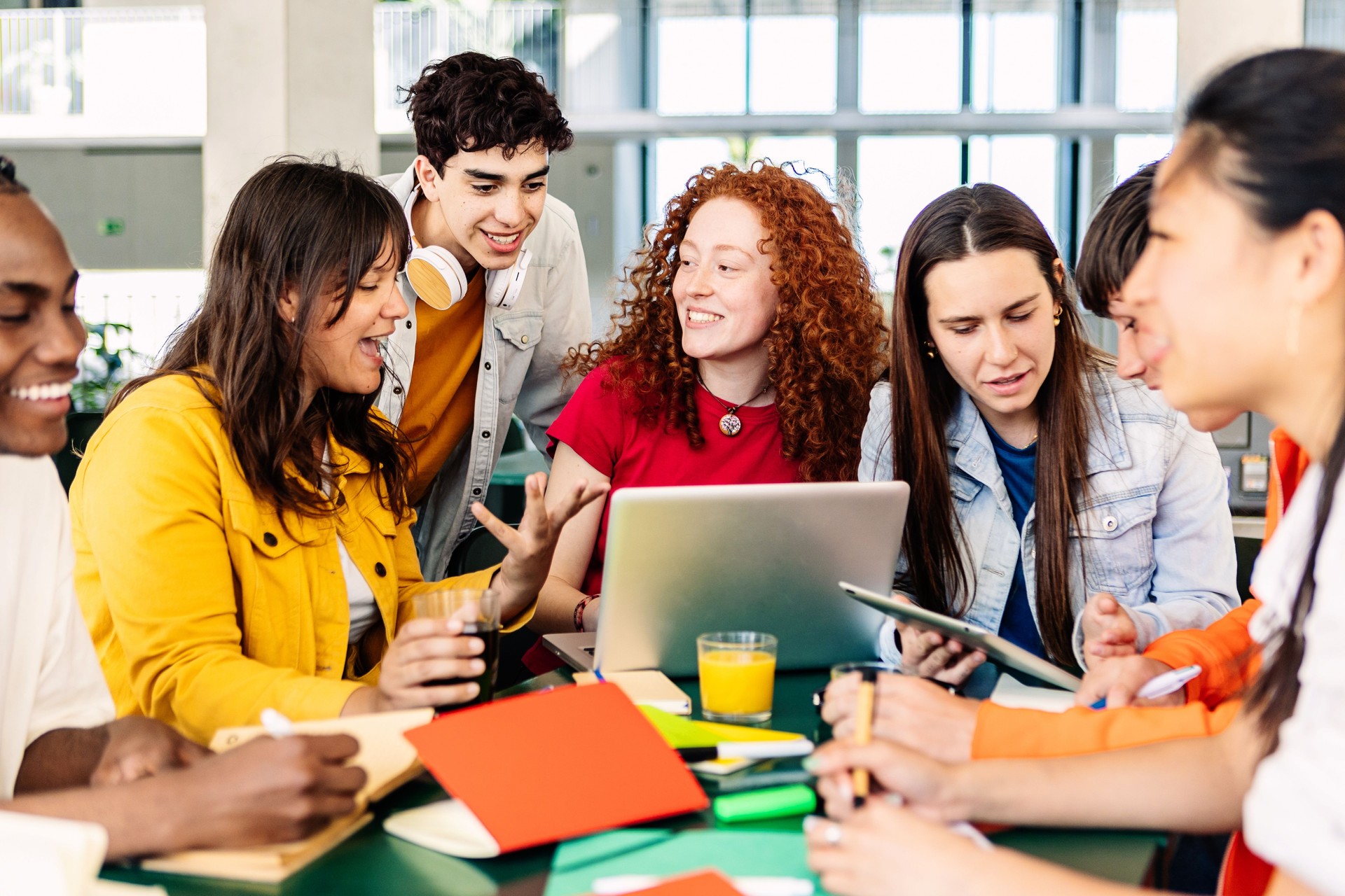 Group of college people studying together on cafeteria table at campus